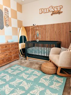 a baby's room with a surfboard on the wall and a rug in the floor