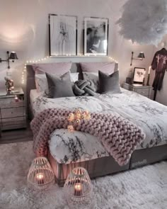 a bed with pillows and blankets on top of it in a room filled with lights