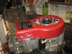 a red engine sitting on top of a table in a room filled with other items