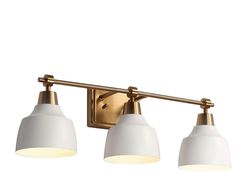 three light bathroom fixture with brass finish and white glass shades on the bottom half of the lights