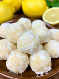 a plate full of lemon snowballs next to some lemons