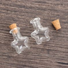 two small glass bottles with corks on a wooden surface, one is empty and the other has a cork stopper