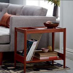 a living room with a couch, coffee table and books on the shelf next to it