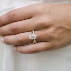 a close up of a person wearing a ring with a diamond on it's finger