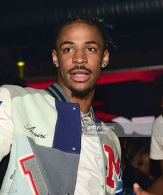 a young man with dreadlocks standing in front of a crowd at an event