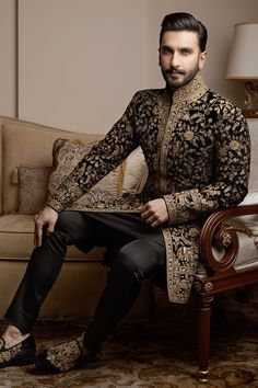 a man sitting on top of a couch next to a chair