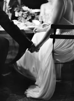 black and white photograph of a couple holding hands in front of a dining room table