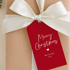 a present wrapped in brown paper with a white ribbon and merry christmas tag on it