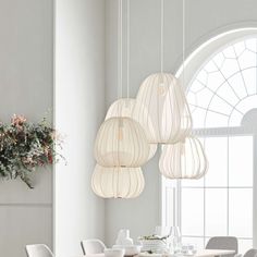 a dining room table and chairs with hanging lights