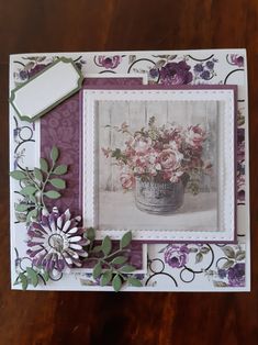 a close up of a card on a table with flowers and a flower pot in it