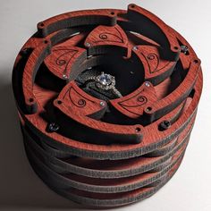 an intricate wooden box with a ring in the middle