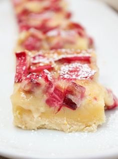 a close up of a plate of food with fruit on it and the words citrus rhubarb custard bars