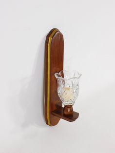 a wooden shelf with a glass vase on it