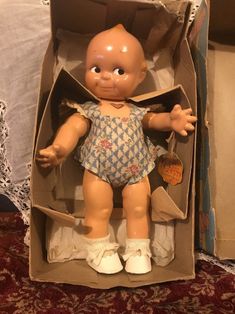 a doll in a box on a bed