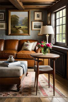 a living room with leather furniture and paintings on the wall above it's fireplace