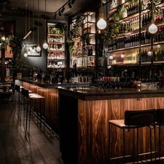 a dimly lit bar with lots of bottles on the shelves and lights hanging from the ceiling