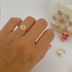 Dainty daisy ring Measures in millimeters: * Jewelry wire: 1 mm * Gold plated metal bead: 3 mm * Pearls: 3 mm Care Information: * FLEXIBLE RING, so it must be handled with care. If the ring loses its shape, you can easily wrap it around a round object to return it to shape. * Avoid contact with water and products such as perfumes and creams. * Store it in a dry place. Shipment information: * Purchases will ship within 1-2 business days. * I'll send this item in a nice cloth bag so you have somewhere to store it when you're not using it. If you have any questions send me a message. Thanks for visiting 💗 Flower Bead Ring, Pearl Flower Ring, Bubble Ring, Ring Wire, Wire Flowers, Daisy Ring, Metal Bead, Simple Gift, Swirl Ring