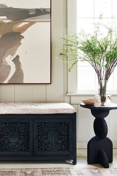 a black bench sitting next to a vase with flowers