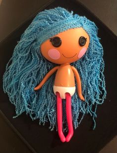 a cake shaped like a doll with blue hair