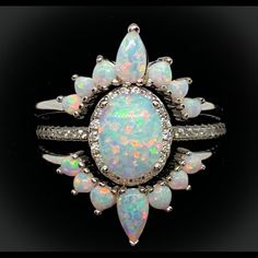 This Elegant White Fire Opal Is Set In A Diamond Halo Of Sparkling Cz's And Surrounded By Two White Fire Opal Crown Bands. With Graduated Opals This Set Features 3 Pieces. Our White Fire Opal Ring ( Center Stone Approximately 1 1/2 Carats) And 2 Fitted Opal Crown Bands. 925 Sterling Silver. Indicate The Size You Require In Comments Opal Wedding Set, Opal Crown, Antique Opal Ring, Opal Wedding Ring Set, Opal Engagement Ring Set, Iridescent Color, Opal Wedding, White Opal Ring, Opal Wedding Rings