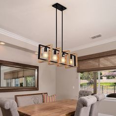 a dinning room table and chairs in front of a window with the lights on