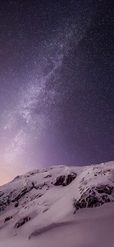 the night sky is filled with stars above snow covered mountains