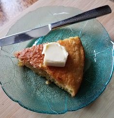 a piece of pie on a glass plate with a knife and fork