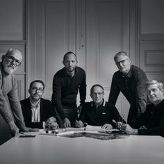 black and white photograph of five men sitting around a table