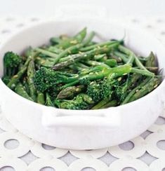 a white bowl filled with broccoli on top of a table