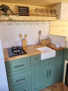 a kitchen with green cabinets and white walls