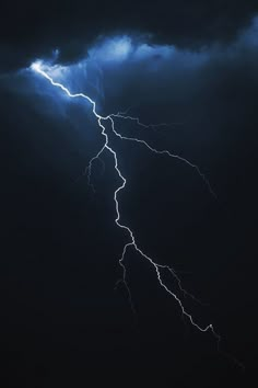 a lightning bolt is seen in the dark sky