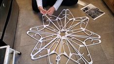 a person is sitting on the floor working on some art work that looks like a snowflake