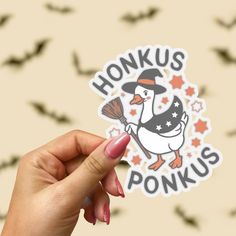 a person holding up a sticker that says honks ponkus