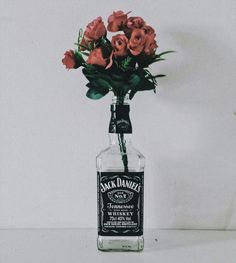 a bottle filled with flowers sitting on top of a table