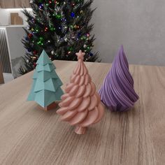 three small christmas trees sitting on top of a wooden table