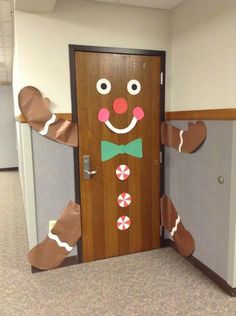 a door decorated to look like a ginger with candy canes on his nose and bow tie