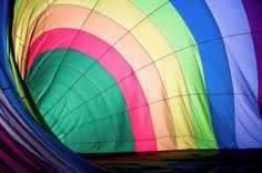 the inside of a colorful hot air balloon with many colors on it's side