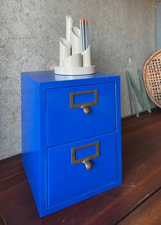 a blue file cabinet sitting on top of a wooden table