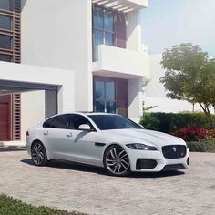 a white car parked in front of a house