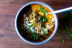 a white bowl filled with food on top of a wooden table and garnished with parsley