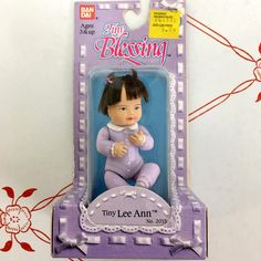 a toy doll sitting on top of a purple and white box with the words tiny lee ann