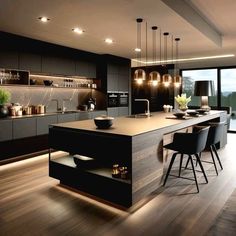 a modern kitchen with wooden floors and black cabinets