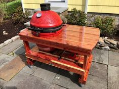 a big red grill sitting on top of a wooden table