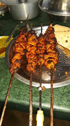 several skewers of food sitting on top of a metal tray