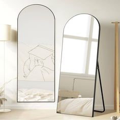 a large mirror sitting on top of a floor next to a bed