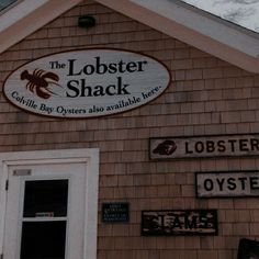 the lobster shack sign is on the side of the building with other signs above it