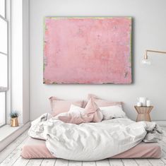 a large pink painting hanging above a bed