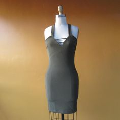 a dress on a mannequin in front of a brown wall with an orange background