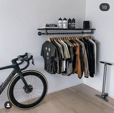 a bicycle is parked next to a rack with shirts on it