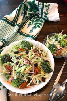 a salad with broccoli, carrots and raisins in a bowl